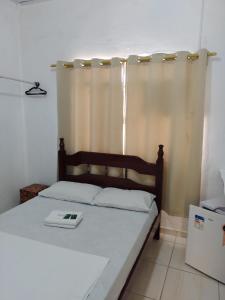 - une chambre avec un lit et un livre dans l'établissement Pousada GEF Aparecida, à Aparecida