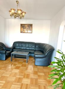 a living room with a black leather couch and a table at Vintage Bucharest apartment in Bucharest
