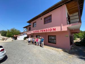 KaracasuElmas Pansiyon的一群站在粉色建筑前面的人