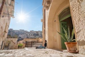 a woman sitting in an alley looking out at the city at La Casa di Ele in Matera