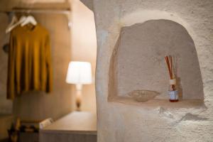 マテーラにあるラ カーサ ディ エーレのランプとボトルが壁に掛けられた部屋