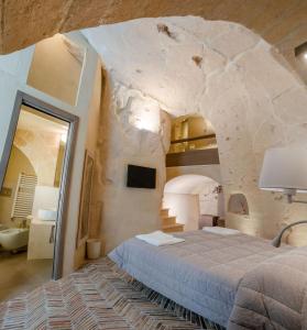 a bedroom with a bed in a stone wall at La Casa di Ele in Matera