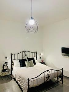 een slaapkamer met een bed en een hanglamp bij Figurari Home Napoli-2 in Napels