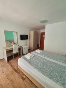 - une chambre avec un lit, un bureau et un miroir dans l'établissement Hotel Char, à Primorsko