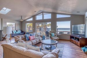 a living room with a couch and a tv at Miss Olena in Seal Rock