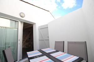 a table and chairs on the balcony of a house at Le Clos des Flots - La Dune in La Flotte