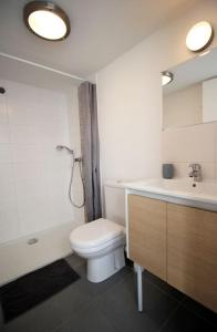 a bathroom with a white toilet and a sink at Le Clos des Flots - La Dune in La Flotte
