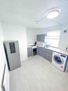 a kitchen with a refrigerator and a washer at Spacious Two Bedroom flat in Hither Green