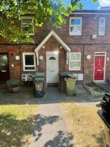 a brick house with a white door and a red door at Spacious Two Bedroom flat in Hither Green