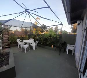 un patio con mesa, sillas y sombrilla en Alquiler temporario para 10/12 en Mar del Plata