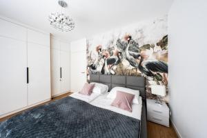 a bedroom with a bed with a painting on the wall at AZURE PREMIUM Dreams in Kołobrzeg