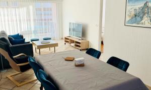 a room with a table and chairs and a television at Appartement CITY CENTER-SALLANCHES in Sallanches