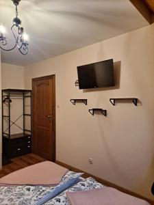 a bedroom with a bed and a tv on the wall at Willa Wschód Słońca in Bukowina Tatrzańska