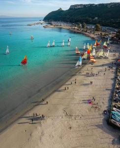 a group of people on a beach with sail boats at Trilocale Margine Rosso in Quartu SantʼElena