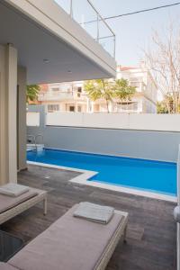 a swimming pool with two chaise lounges next to a building at Palmyra Athens in Athens