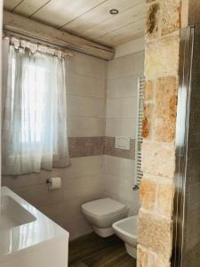 a bathroom with a white toilet and a sink at La linea dell'orizzonte in Alberobello