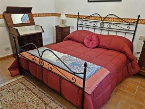 a bedroom with a bed with a red comforter at Casa Vacanze Nives in Tuscania