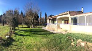 una casa en un campo con un patio de hierba en La maison des Sources, en Salon-de-Provence