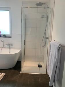 bagno con doccia, vasca e lavandino di Beautiful modern country home a Wegberg