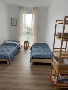 1 dormitorio con 2 camas, escalera y ventana en Beautiful modern country home, en Wegberg