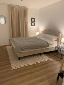 a bedroom with a large bed and two lamps at Beautiful modern country home in Wegberg