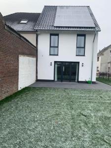 a white house with a window and a brick wall at Beautiful modern country home in Wegberg