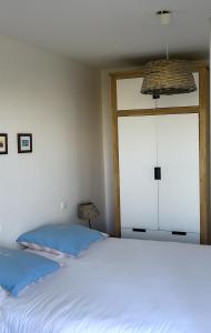 een slaapkamer met een groot wit bed en een raam bij LE BORD de MER in Calais