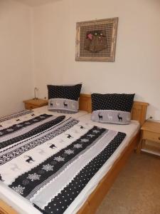 1 dormitorio con 2 camas y sábanas blancas y negras en Gemütliche Ferienwohnung in Weidach, en Leutasch