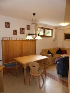 sala de estar con mesa de madera y sofá en Gemütliche Ferienwohnung in Weidach, en Leutasch