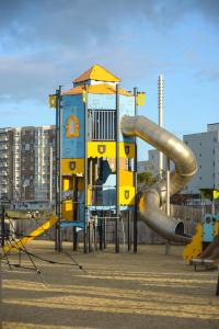 een speeltuin met een glijbaan in een park bij LE BORD de MER in Calais