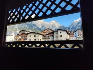 una vista da una finestra di una città con montagne di Hometoday - Appartamento nel cuore di San Vito di Cadore a San Vito di Cadore