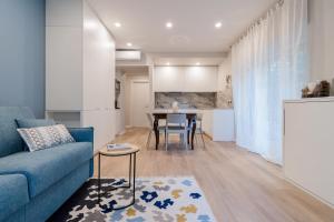 uma sala de estar com um sofá azul e uma mesa em Ariston & Casinò - Appartamento con Giardino e Garage em Sanremo