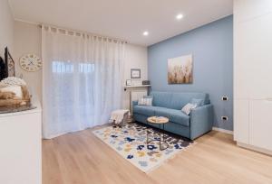 a living room with a blue couch and a rug at Ariston & Casinò - Appartamento con Giardino e Garage in Sanremo