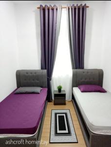 - 2 lits dans une chambre avec des rideaux violets dans l'établissement Ashcroft homestay, à Kota Bharu
