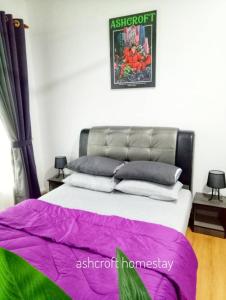 - une chambre dotée d'un lit avec des draps violets et verts dans l'établissement Ashcroft homestay, à Kota Bharu