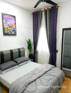 - une chambre avec un lit et une fenêtre avec des rideaux violets dans l'établissement Ashcroft homestay, à Kota Bharu