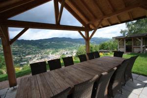 a wooden table and chairs on a patio with a view at Les Authentics-Le Retour aux Sources in La Bresse