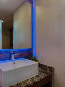 W łazience znajduje się biała umywalka i lustro. w obiekcie Altos de Los Paraísos Vista al lago y sierras w mieście Juana Koslay 