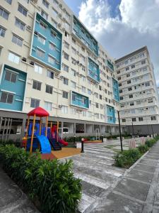 a playground in front of a large building at City Center - front of Iloilo Esplanade 2BR condo in Iloilo City