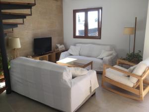 sala de estar con 2 sofás blancos y TV en Apartamento Agua Azul, en Jávea