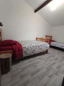 a bedroom with two beds and a wooden floor at Cabaña en playa San Ignacio in Valdivia