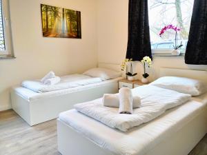 2 camas en una habitación con 2 ventanas en Aparthotel "Dat Witte Hus" Komfortables Apartment für 6 Personen, en Geesthacht