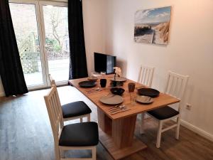 a dining room table with chairs and a wooden table at Aparthotel "Dat Witte Hus" Komfortables Apartment für 6 Personen in Geesthacht