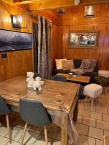 a living room with a wooden table with two teddy bears on it at Chalet Cosy Les Gets Vue Montagne in Les Gets
