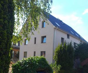 un gran edificio blanco con techo azul en Aparthotel "Dat Witte Hus" Komfortables Apartment für 6 Personen, en Geesthacht