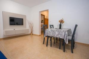a dining room with a table and chairs and a tv at Apartment Ivan 2 in Funtana