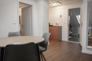 a room with a table and chairs and a kitchen at Hotel Teatro in Kassel