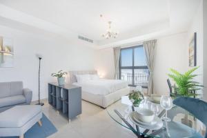 a living room with a bed and a glass table at Elegant Studio with Canal View and Close to Metro in Dubai