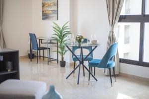 a dining room with a table and blue chairs at Elegant Studio with Canal View and Close to Metro in Dubai