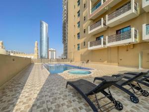 a patio with two chairs and a pool in a building at Elegant Studio with Canal View and Close to Metro in Dubai